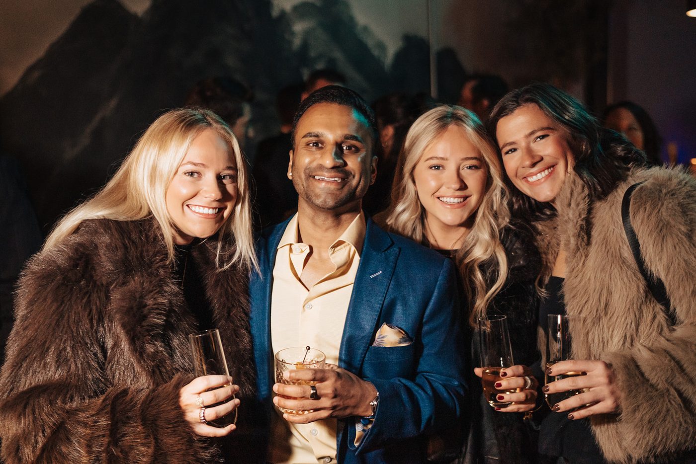 Guests toasting together in fur coats at the gala