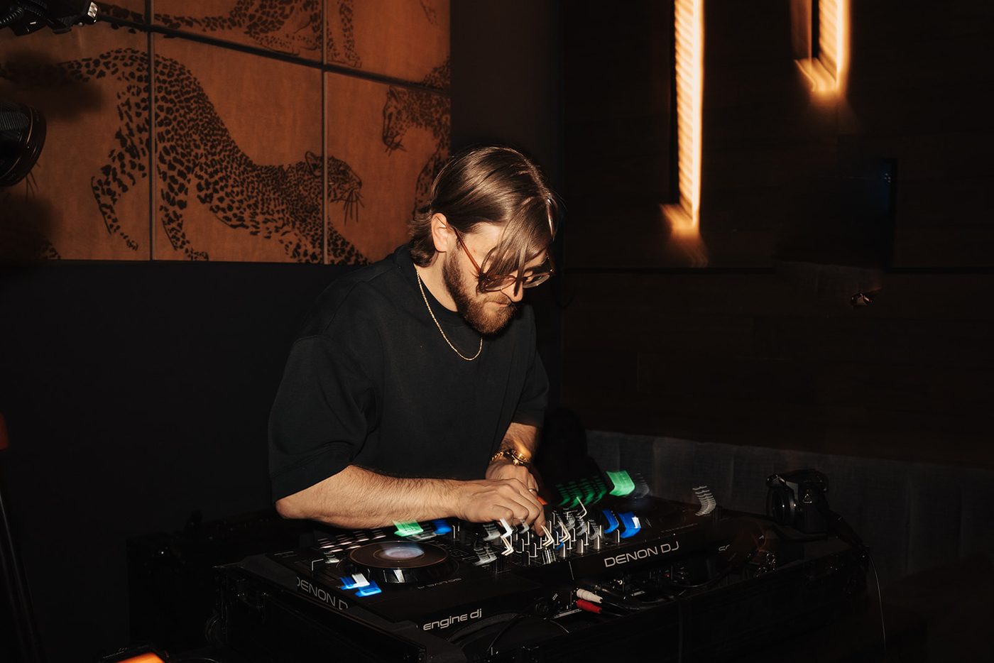 The DJ behind the decks beneath the mountain backdrop