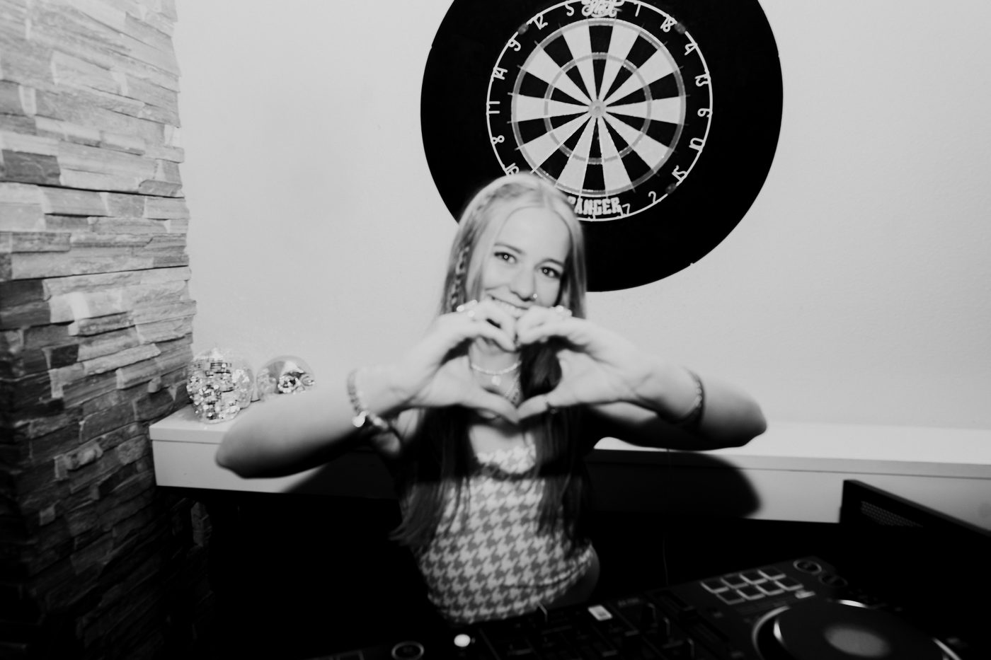 DJ making a heart with her hands behind the decks