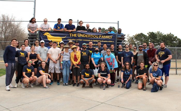 A large group of Underdog Family volunteers behind their banner at a 2022 park day