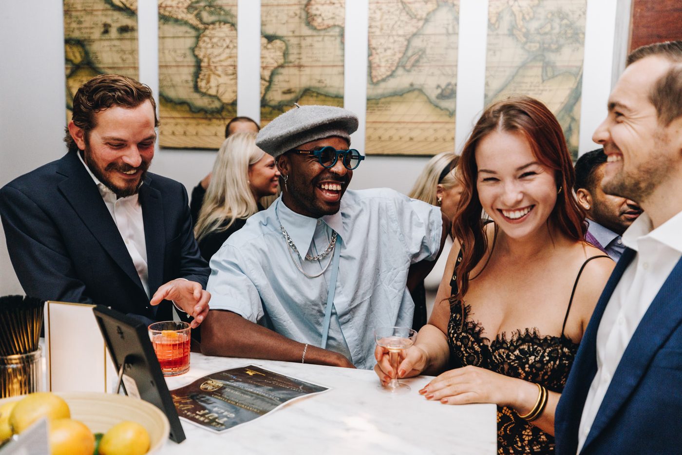 Three friends laughing together at a table at Fall Ball