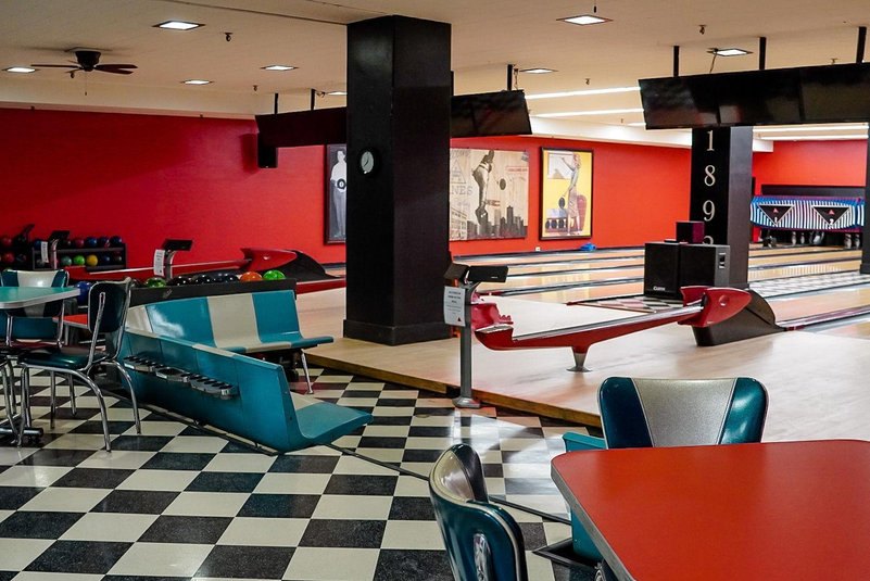 Retro booths and checkered floors beside the lanes at the DAC bowling alley