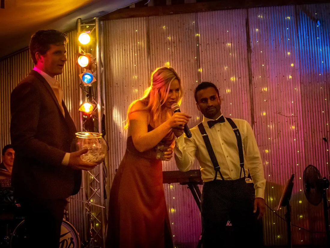 Hosts drawing raffle tickets on stage at the Inaugural Fall Ball