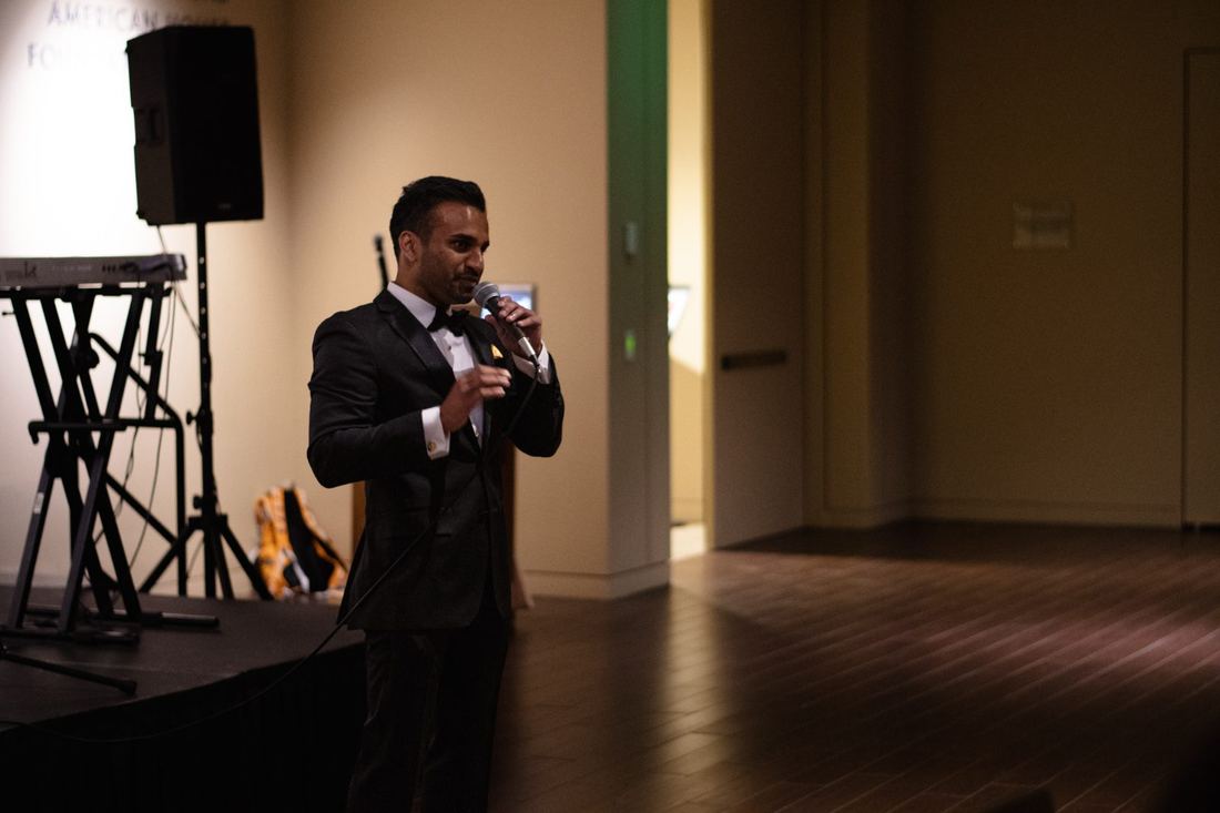 The host in a tuxedo on the mic at the 2022 Fall Ball