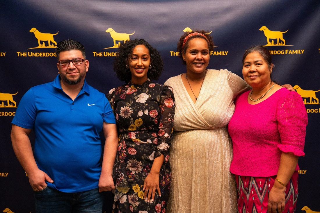 A family posing at the gold TUF step-and-repeat backdrop