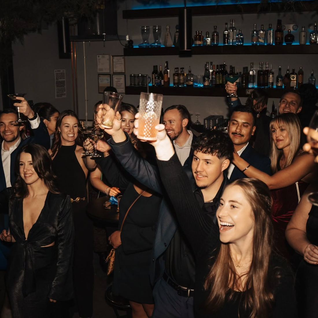 The whole room raising glasses in a toast at TUF Friendsgiving